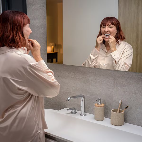 Patiente mettant en place son orthèse devant le miroir
